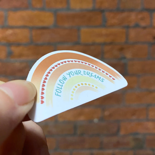 Aesthetic color rainbow sticker with 'follow your dreams' text. Frontal