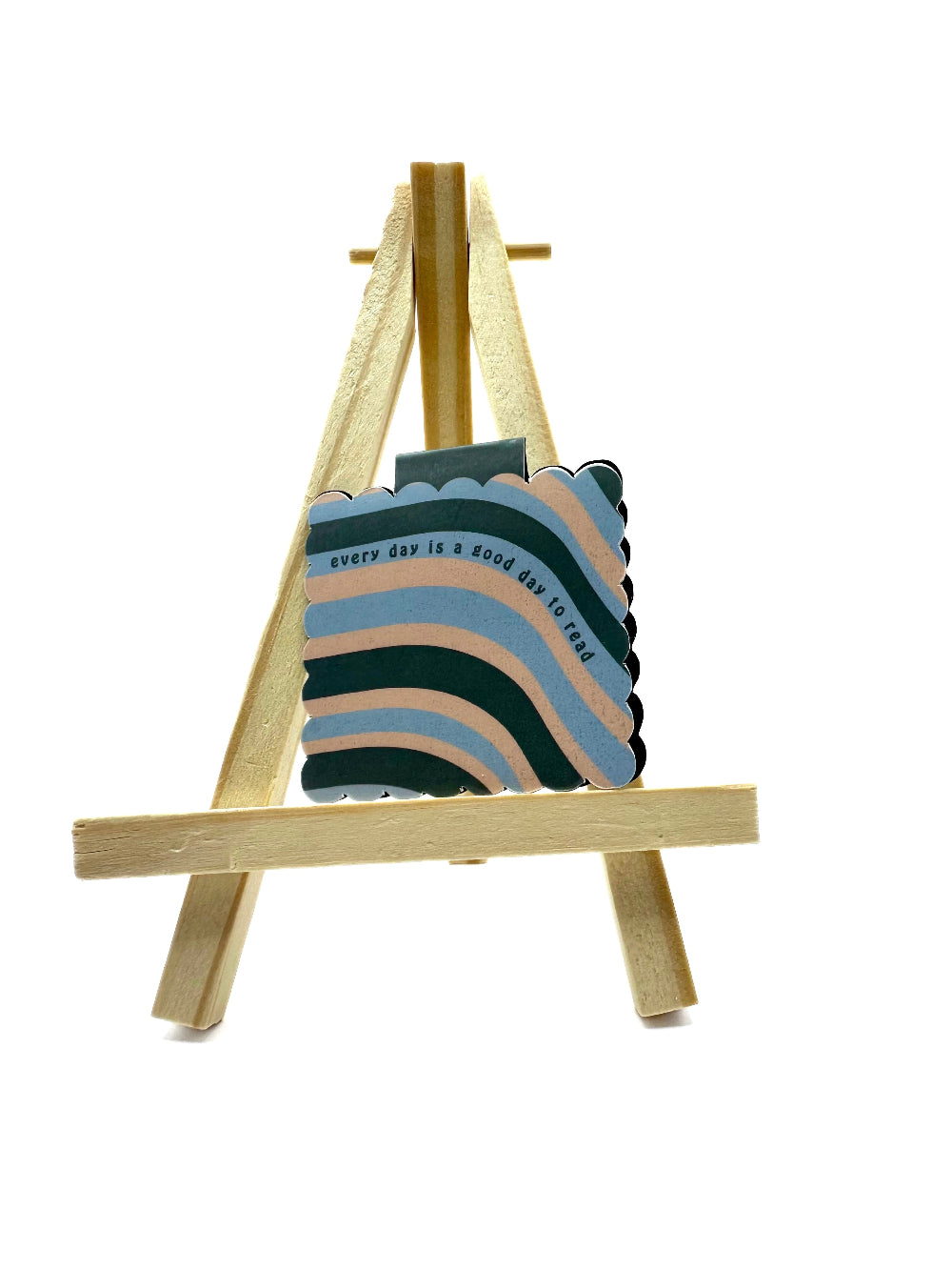 Colorful magnetic bookmark with tex 'every day is a good day to read' on a wooden stand against a white background