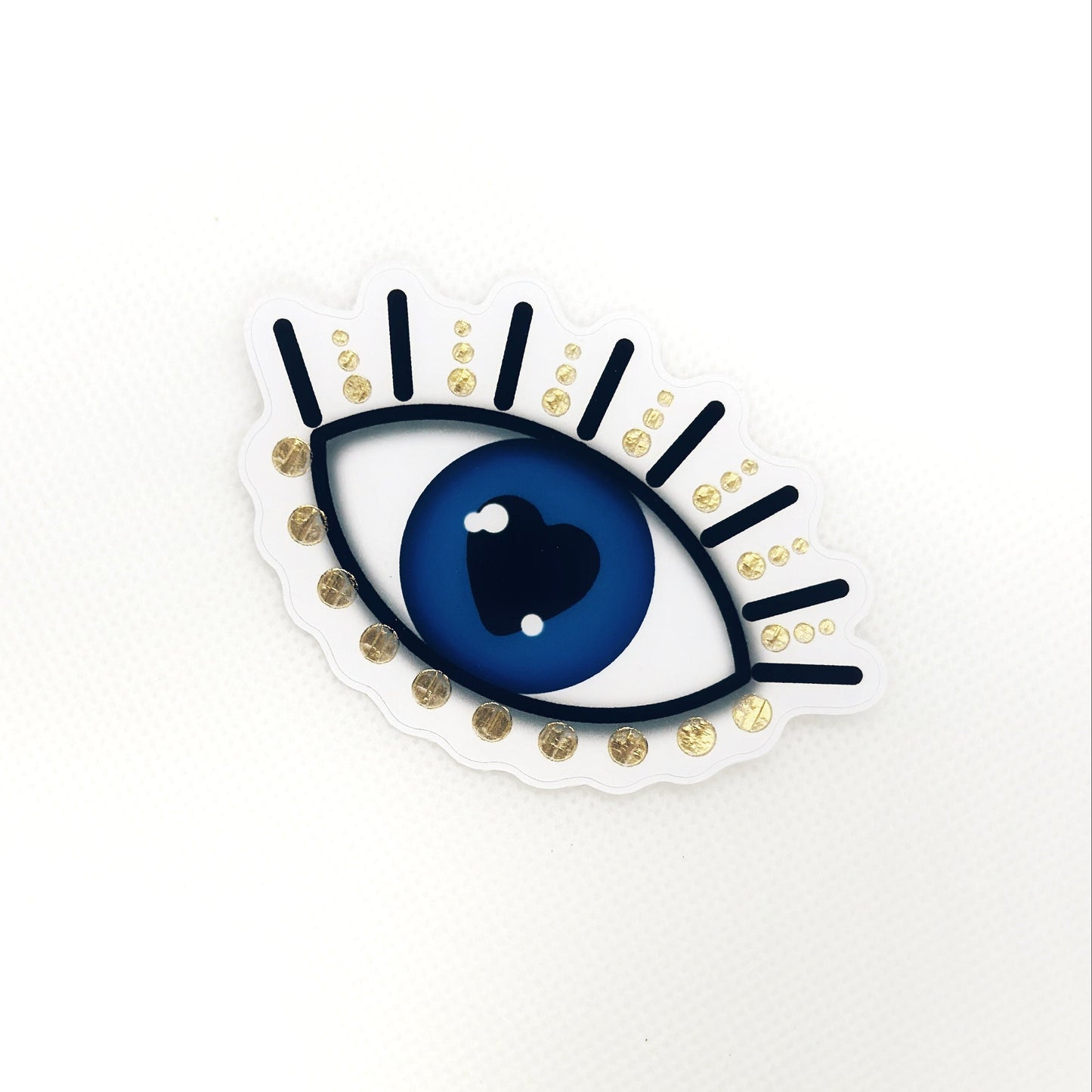 Evil eye sticker with gold details. Top view