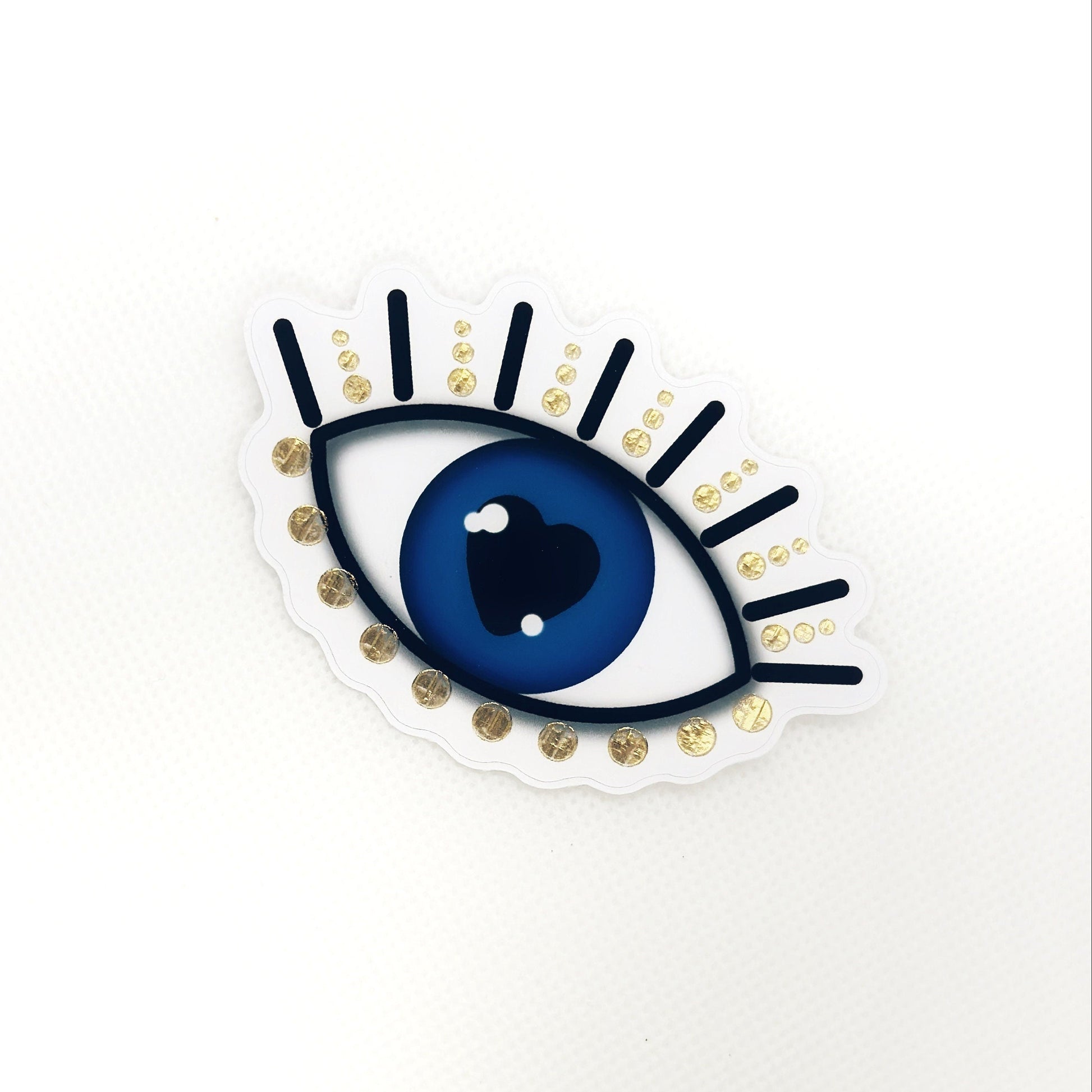 Evil eye sticker with gold details. Top view
