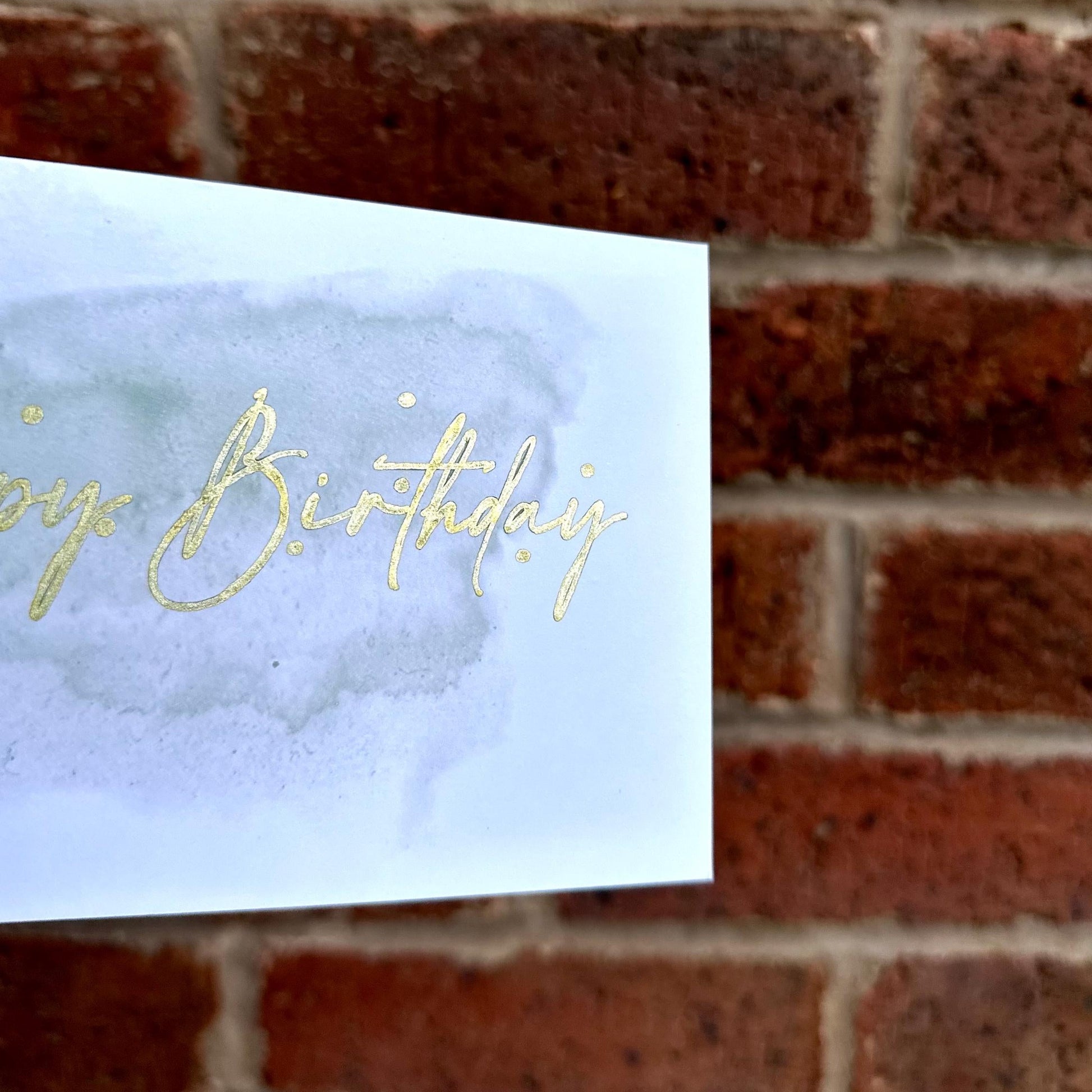 Aesthetic birthday card on watercolour background and gold detail text 'happy birthday'. Frontal detail