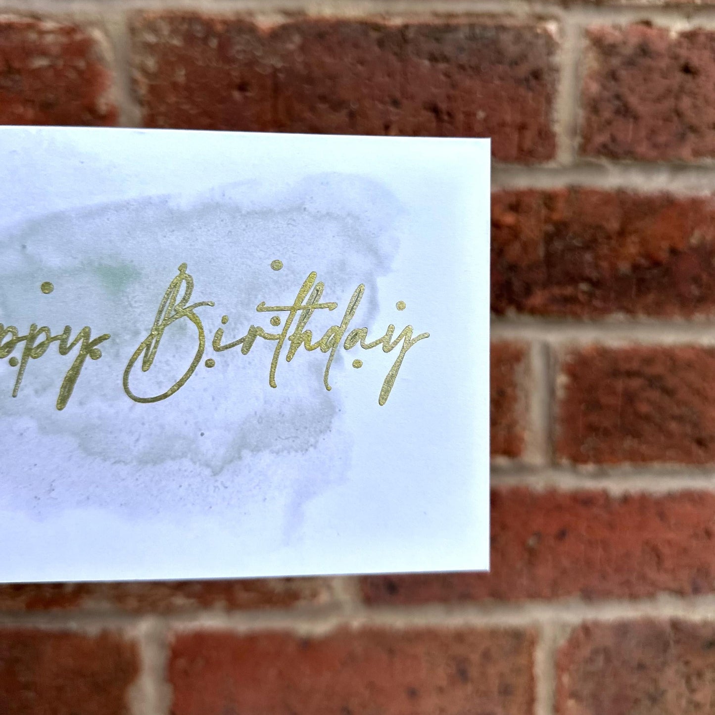 Aesthetic birthday card on watercolour background and gold detail text 'happy birthday'. Frontal detail