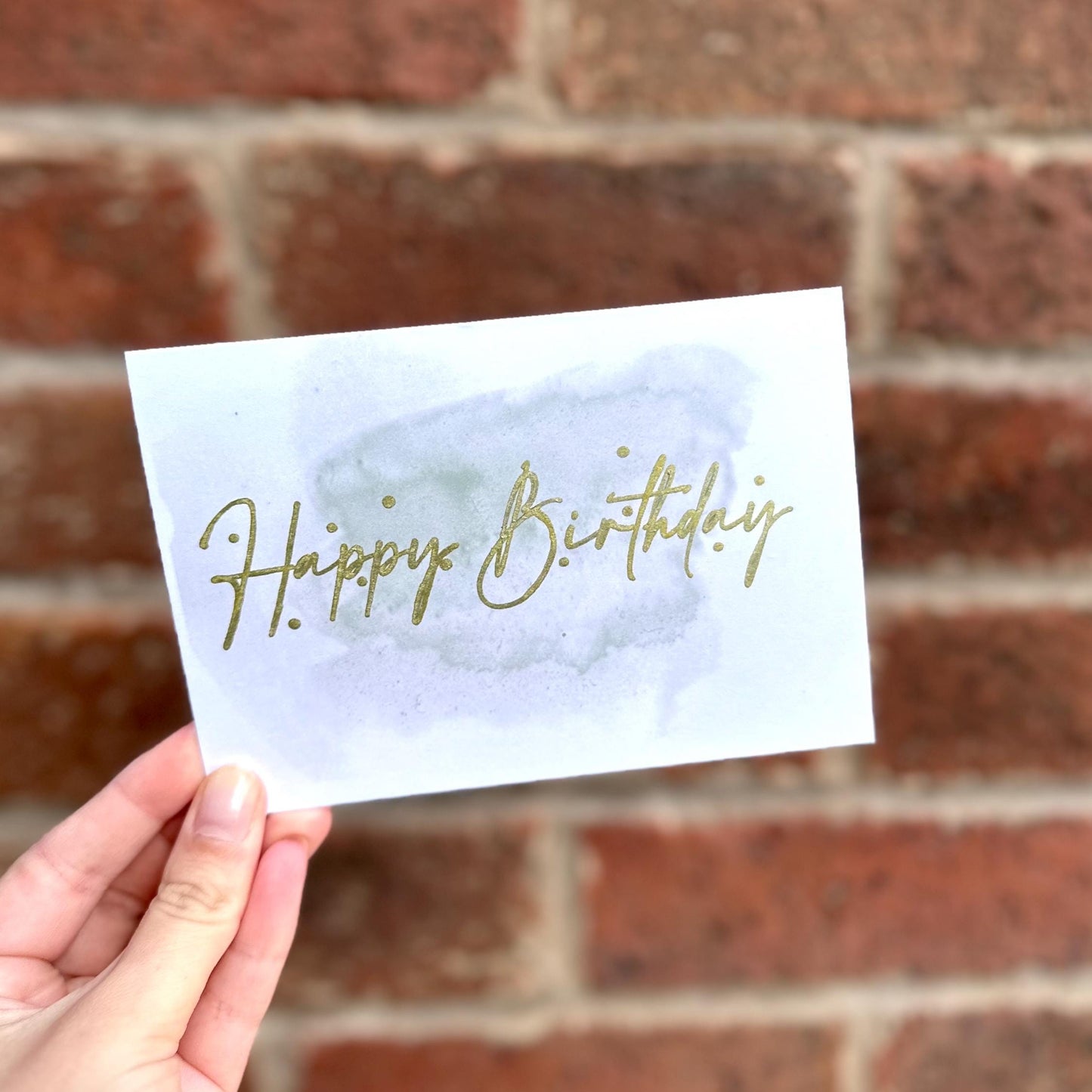 Aesthetic birthday card on watercolour background and gold detail text 'happy birthday'. Frontal detail
