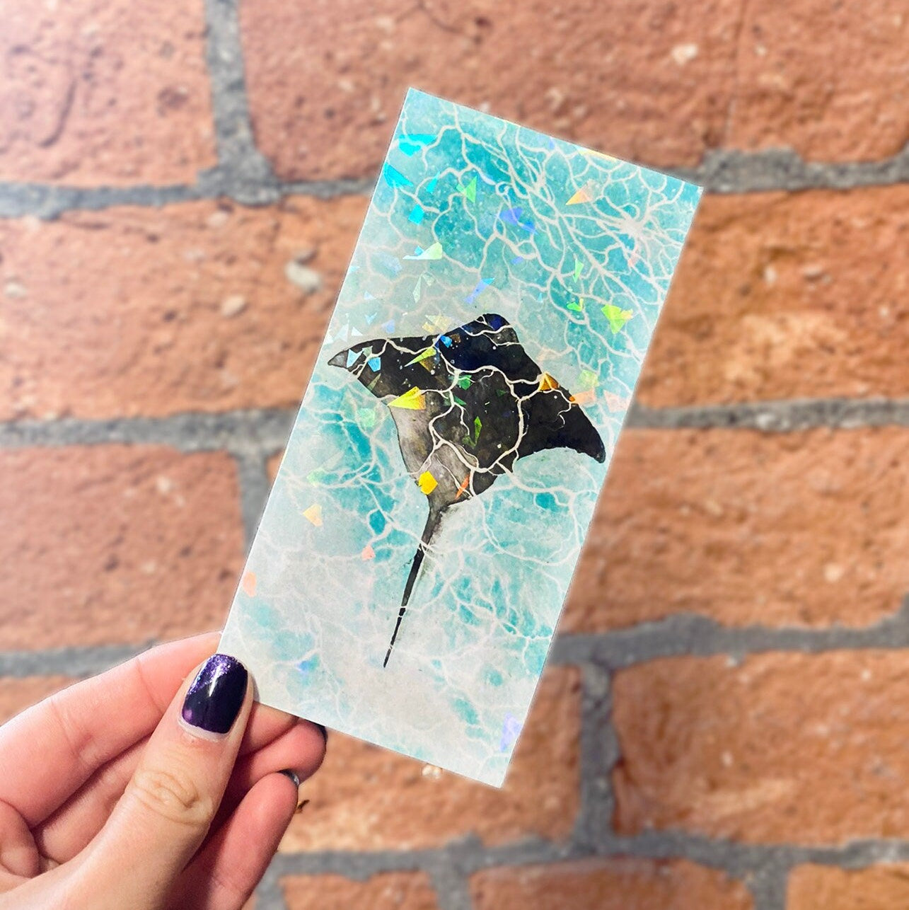 Holographic finish bookmark with a marine ray fish design. Frontal