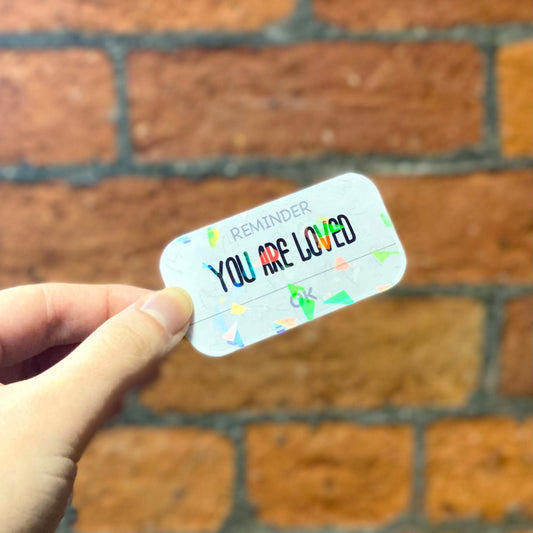Holographic aesthetic sticker with the text 'YOU ARE LOVED'. Frontal