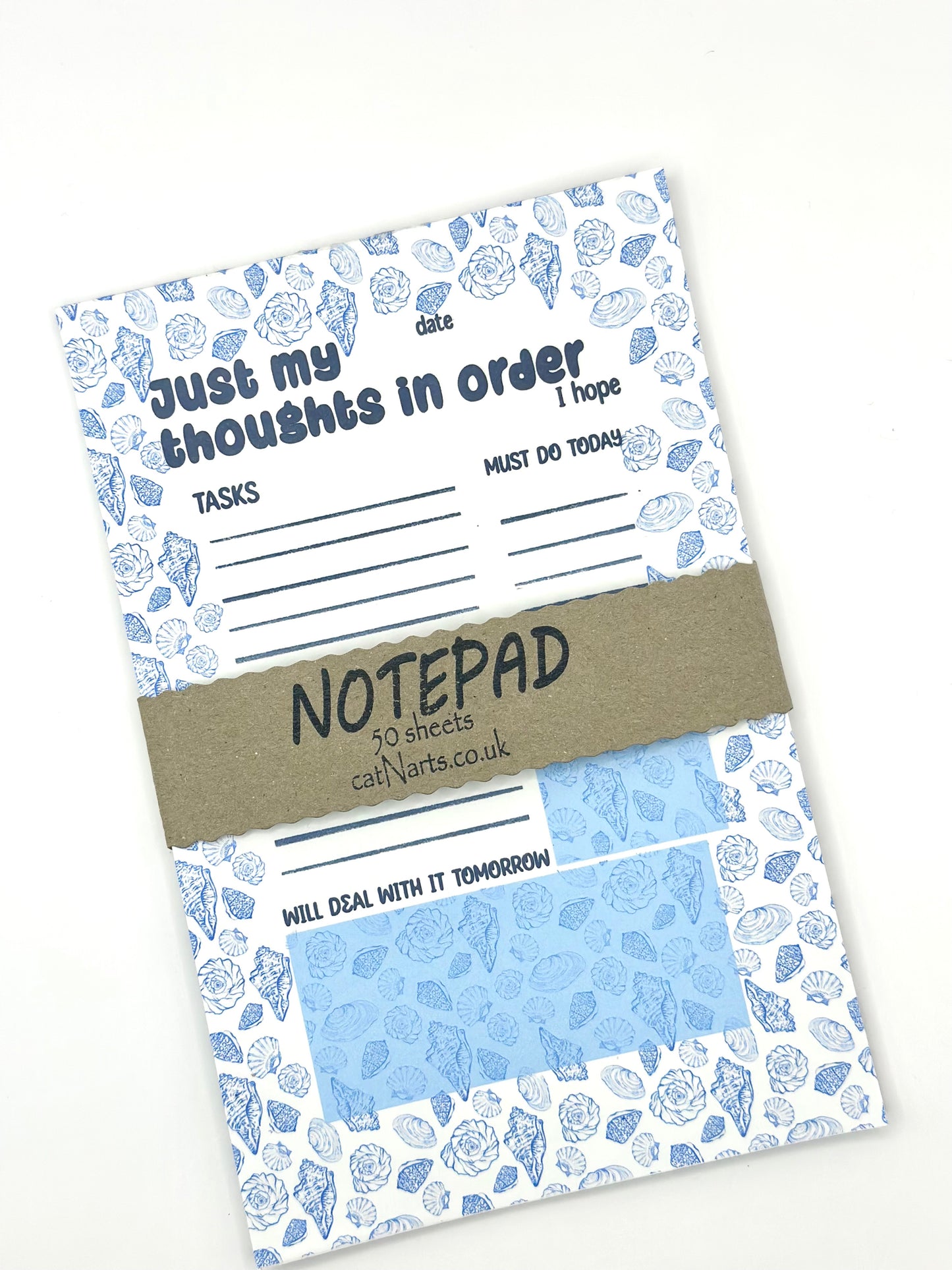 Notepad with coastal design and text 'Just my thoughts in order' on a white background