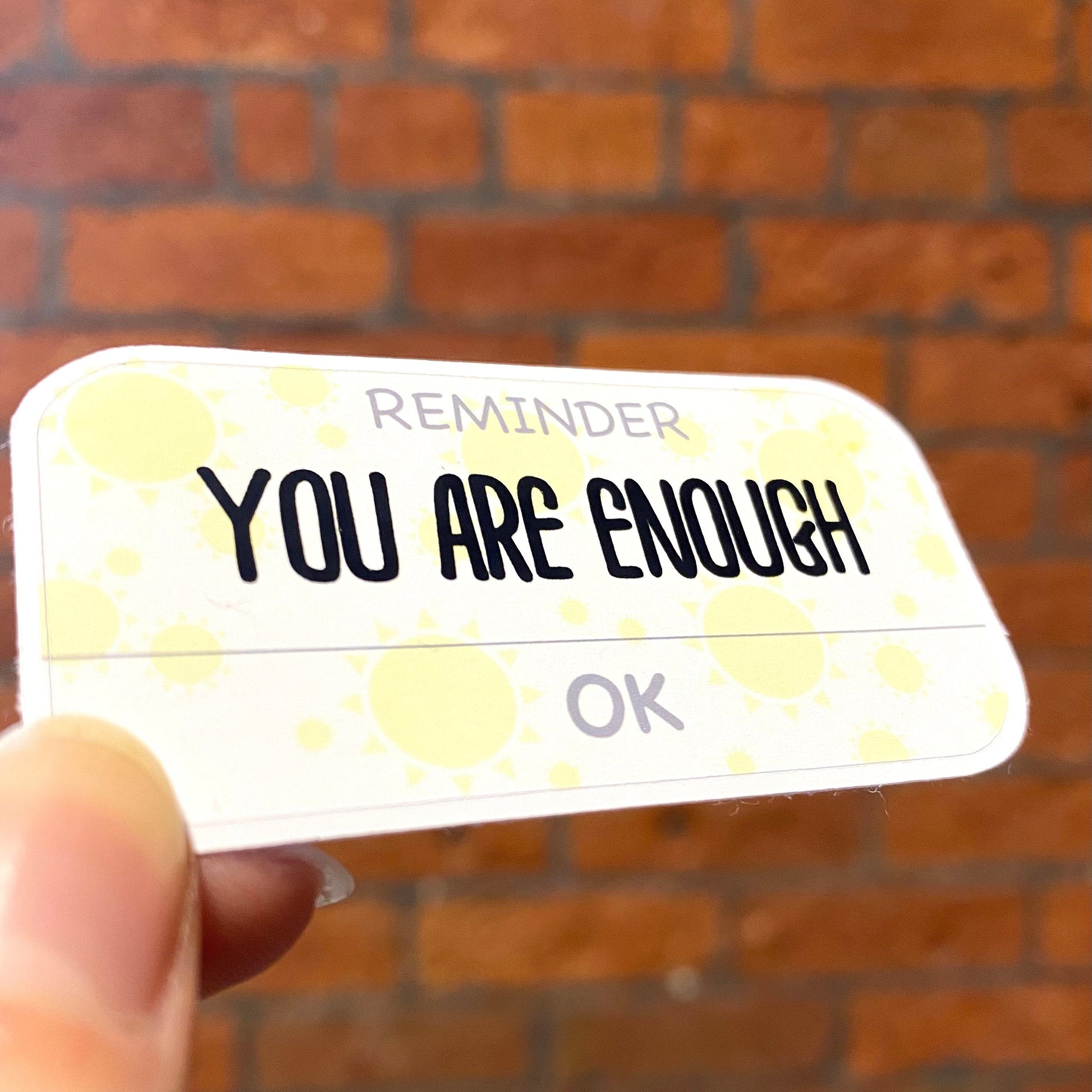 Matte aesthetic motivation sticker with text 'reminder you are enough'. Angle view