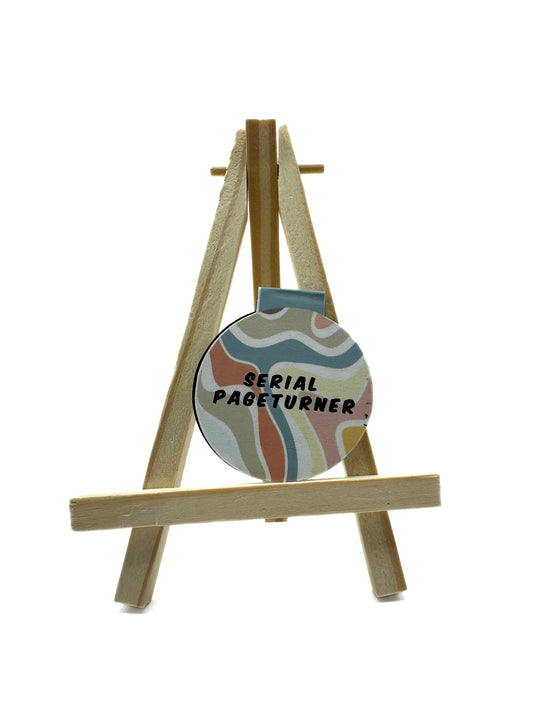 Round magnetic bookmark on a small easel with 'Serial Page Turner' text on colorfull groovy background.