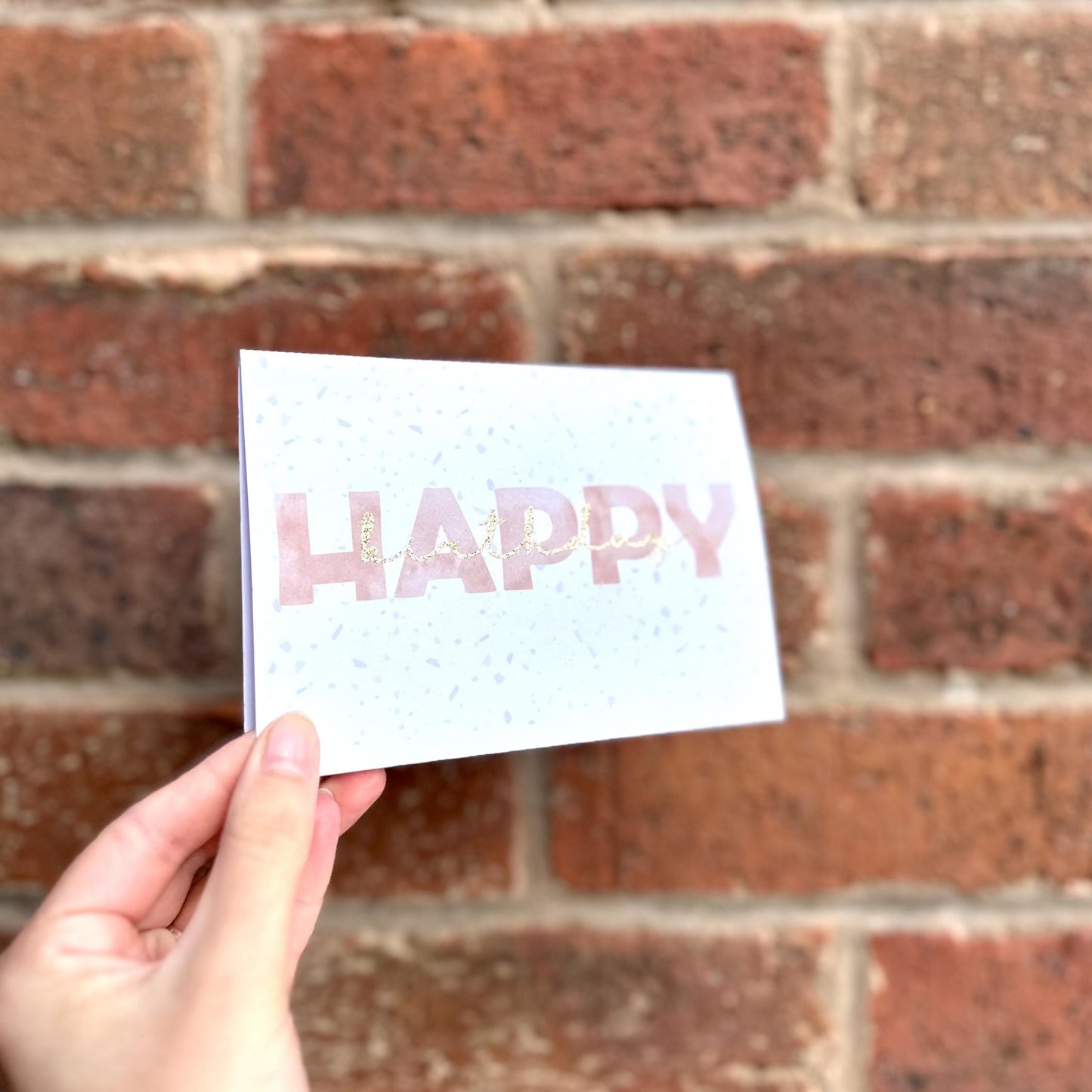 Aesthetic terrazzo detail Happy Birthday card with glitter  birthday text. Angle view