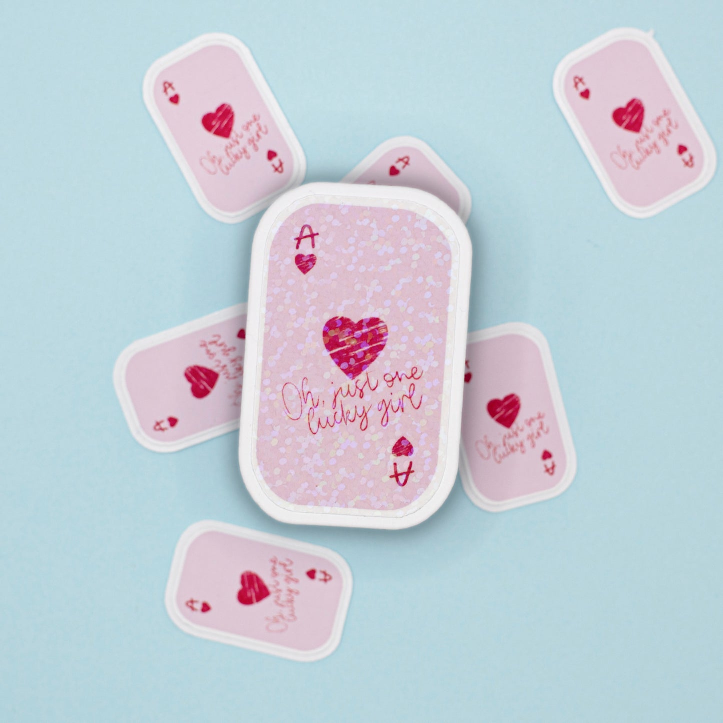 An ace card sticker  on a light blue background. The center cover is labeled 'Ace' with a pink heart and the phrase 'Oh just one lucky girl' in pink script and a holographic dot overlay.
