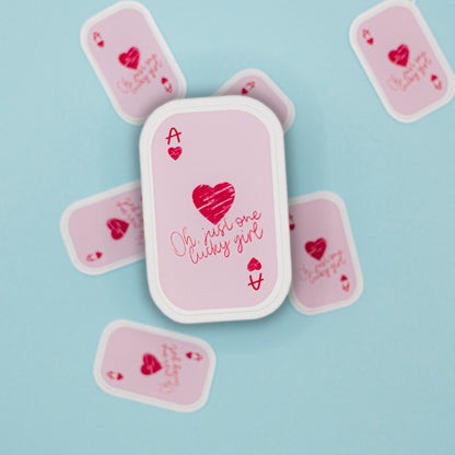 An ace card stickers with white borders, featuring a central Ace of Hearts sticker with the phrase 'Oh, just one lucky girl' in cursive. The stickers are arranged on a light blue background.