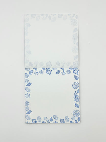 Square memo pad with a blue coastal border pattern, photographed flat against a plain white background.