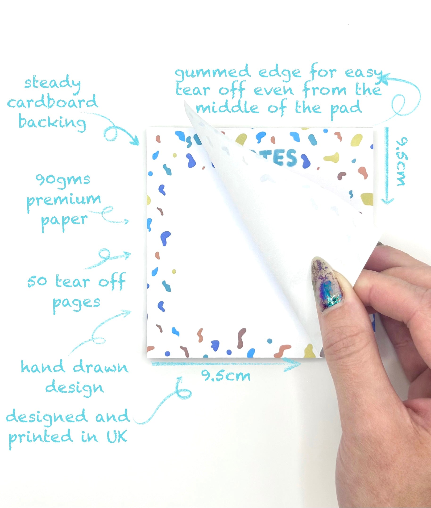 Hand holding a tear-off page of a square confetti themed memo pad with product features highlighted on a white background