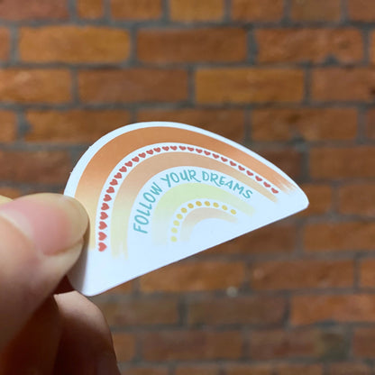 Aesthetic color rainbow sticker with 'follow your dreams' text. Frontal