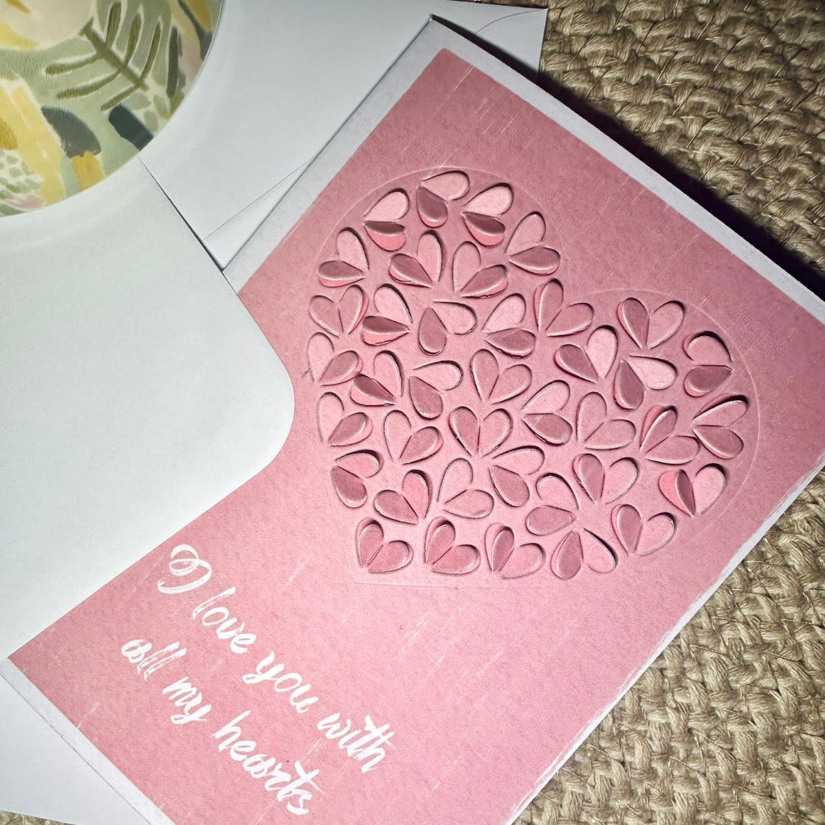 pink valentine day card with cut out hearth shapes and text - i love you with all my hearts on textured background 