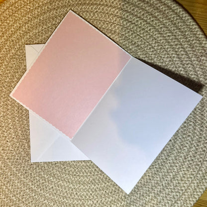 inside of a valentine day card, one sidepink and one white, on a textured surface.