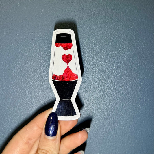 Sticker of a lava lamp with red and black colors held by a hand against a blue background