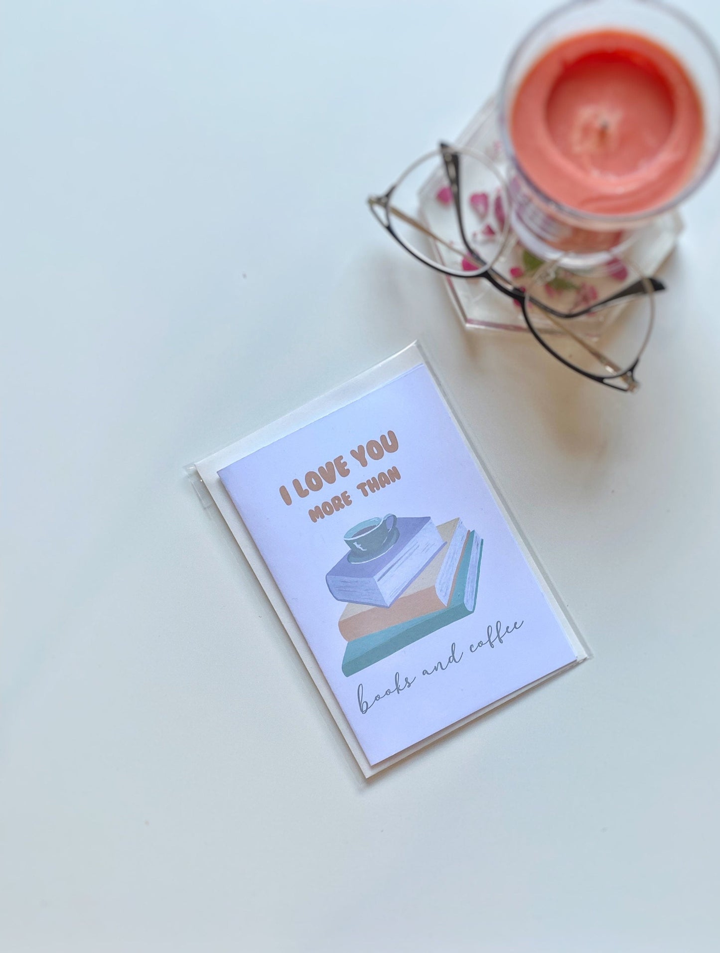A greeting card with the text 'I LOVE YOU MORE THAN books and coffee' displayed with envelope