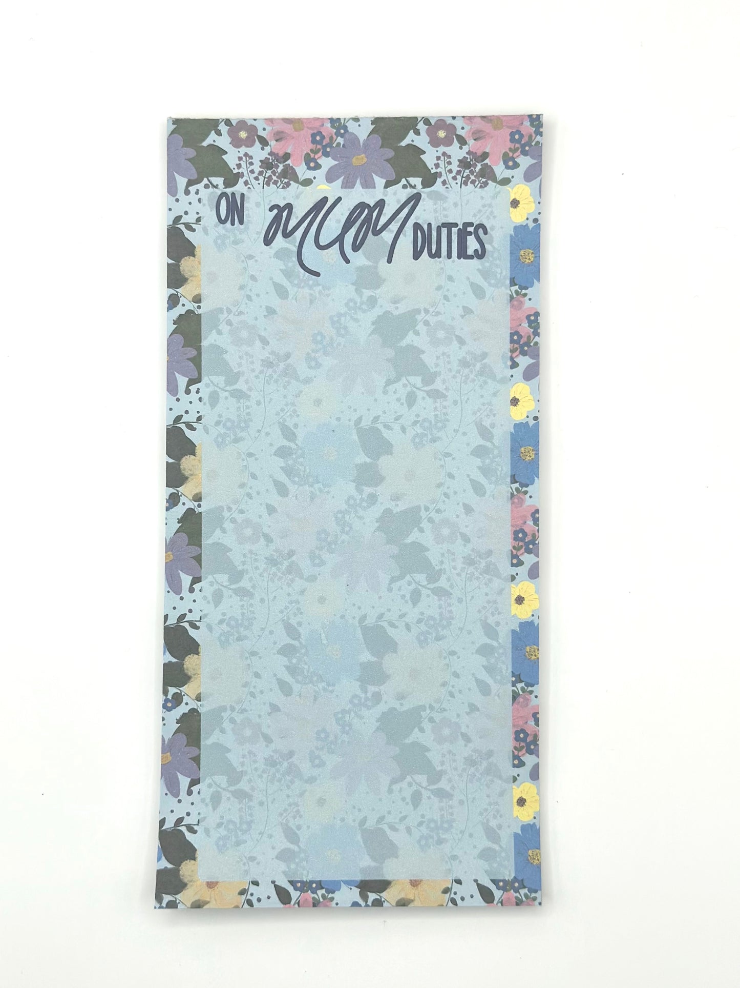 A vertical memo pad with a floral-patterned border and a light blue floral center. The top reads 'ON MUM DUTIES' in stylised lettering.