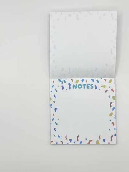 Square memo pad with colorful confetti design and 'Notes' text on a white background