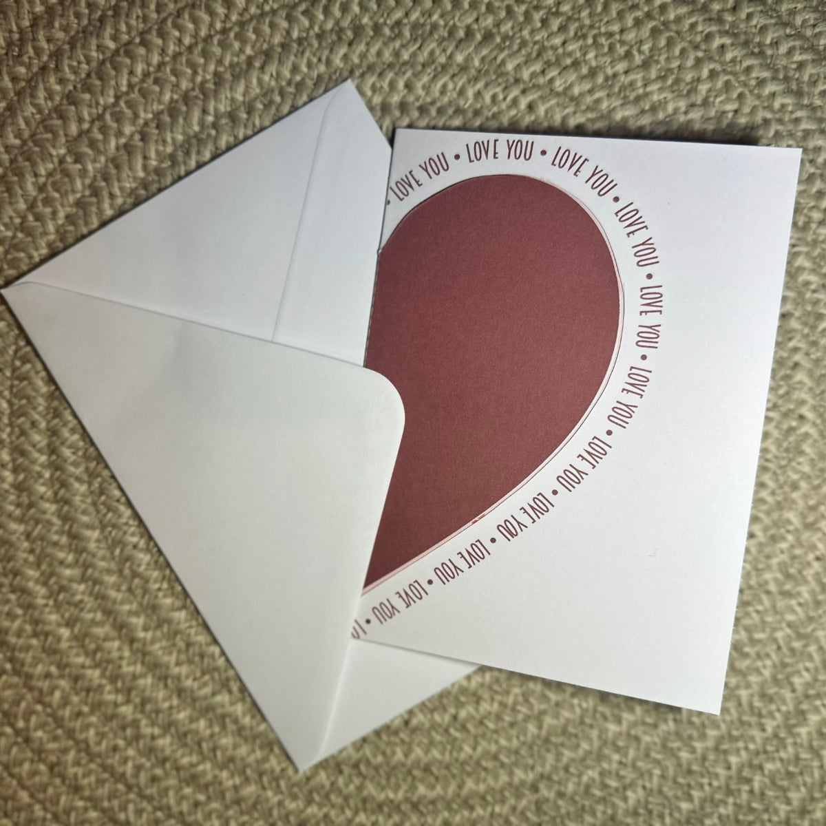 Heart-shaped card with 'I love you' text on a textured surface