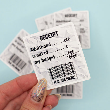 A crumpled white receipt-style sticker with black text reading 'RECEIPT Adulthood is out of my budget flat ass broke'.