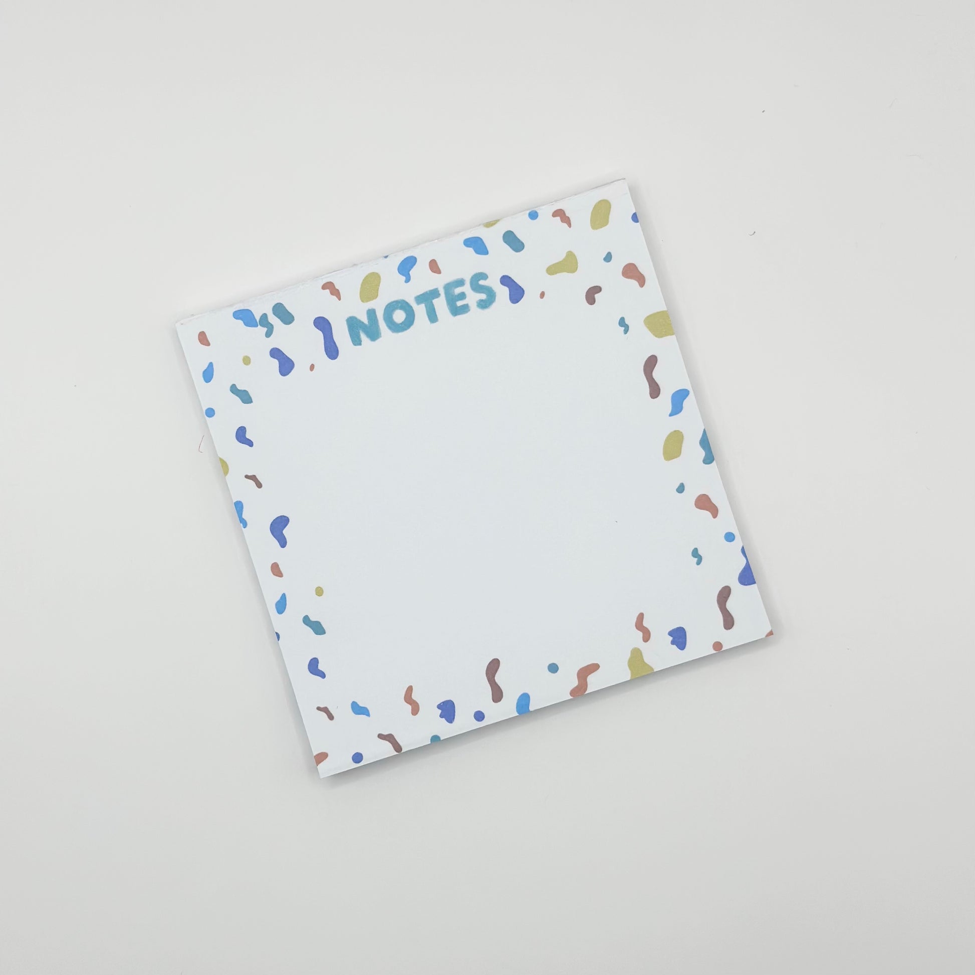 square memo pad with colorful text 'NOTES' and confetti border on a white  background