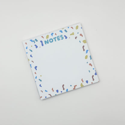 square memo pad with colorful text 'NOTES' and confetti border on a white  background